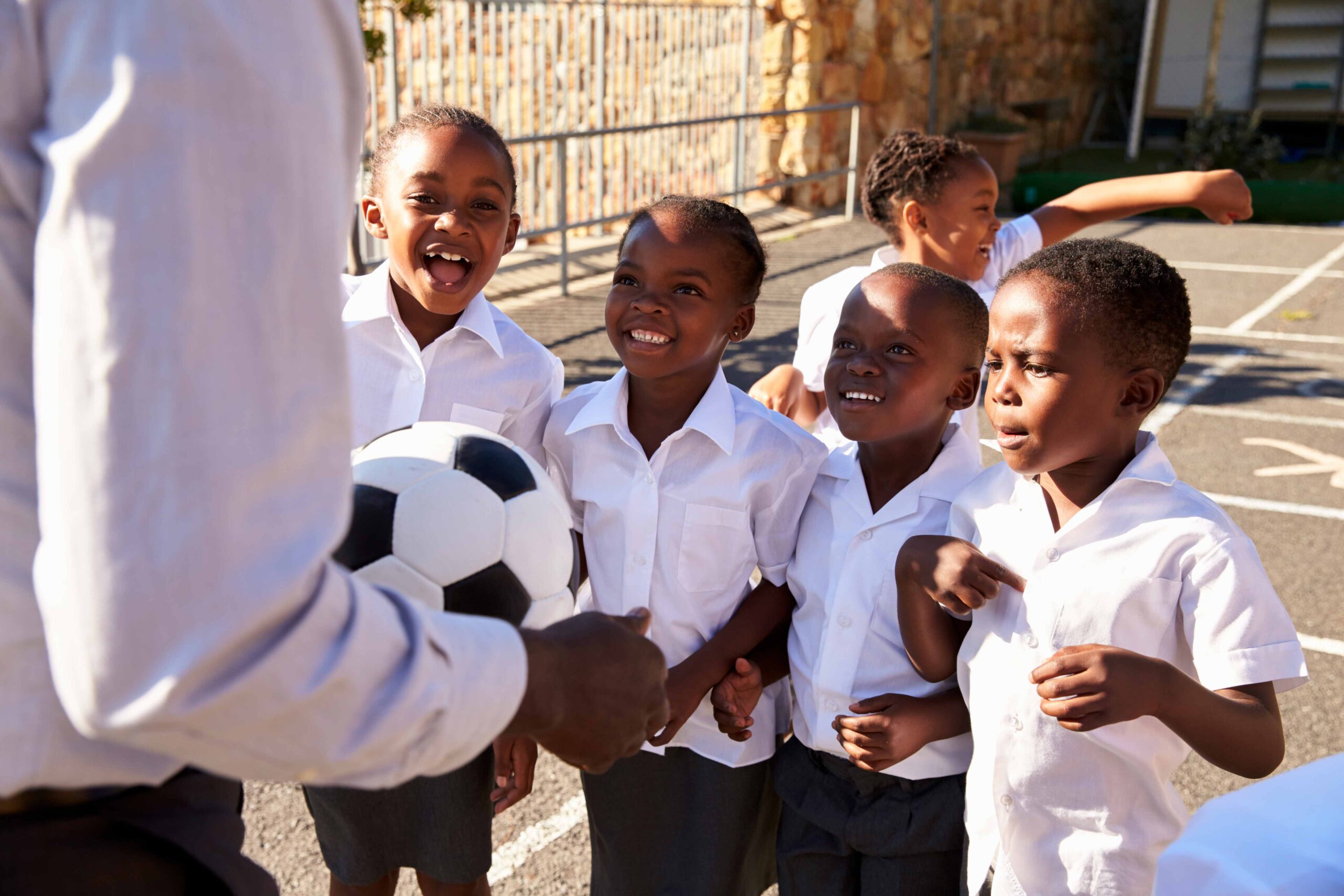 african-student-with-teacher-holding-football